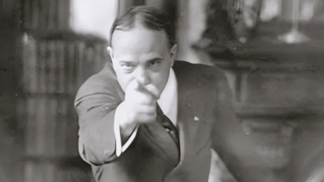 Man in a suit points straight at the camera with a stern, intimidating expression (black-and-white photo).","Black-and-white image of a businessman leaning forward and pointing at the viewer.","A formally dressed man extends his arm toward the camera, appearing to challenge the viewer.